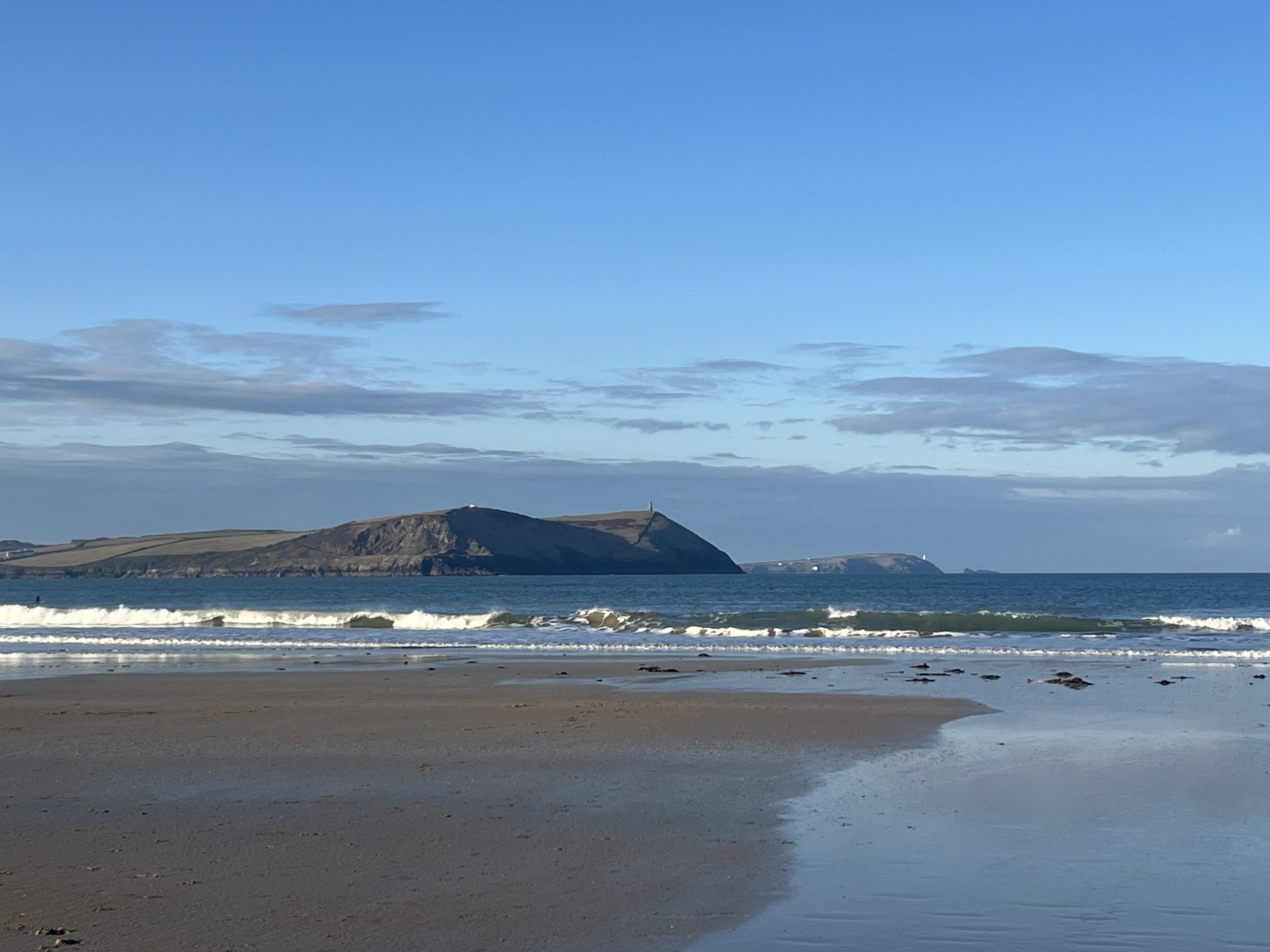 Daymer Bay beach in North Cornwall with waves and coastal headland