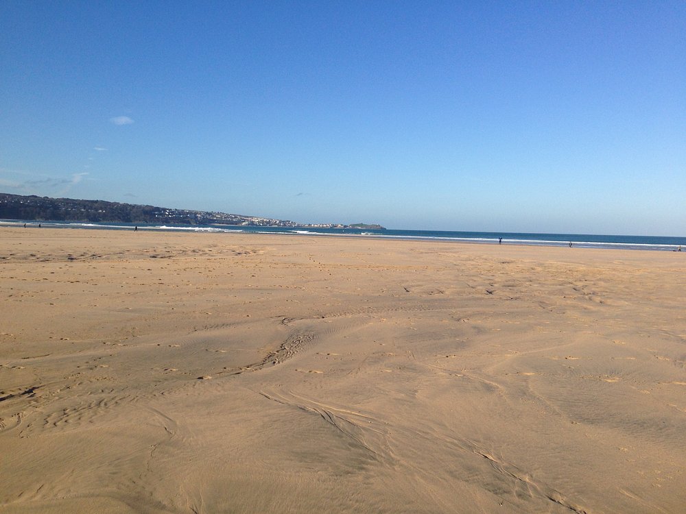 Wide sandy beach at Mexico Towans in Hayle, Cornwall, with open shoreline and blue sky