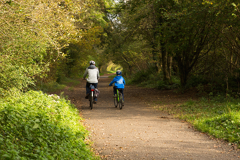 Cyclists riding along the Camel Trail in Cornwall