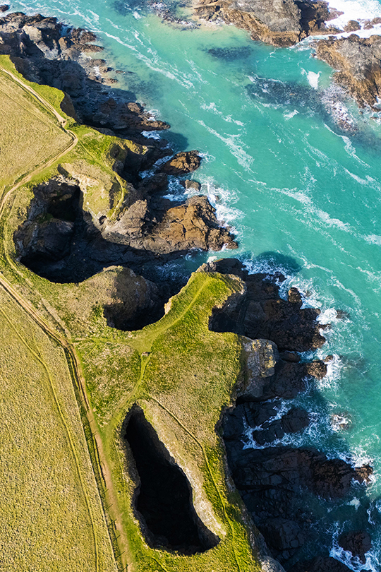 Aerial view of dramatic Cornwall coastline with turquoise sea and rocky cliffs