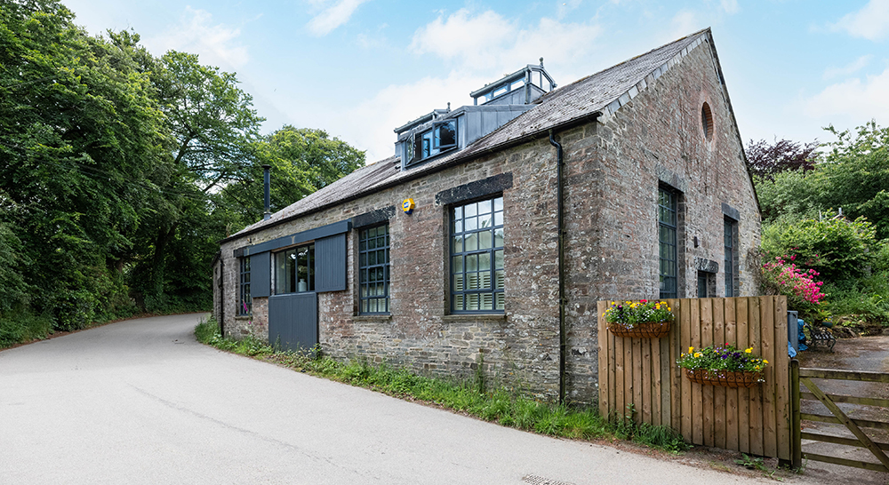 Stone holiday cottage surrounded by trees in Cornwall