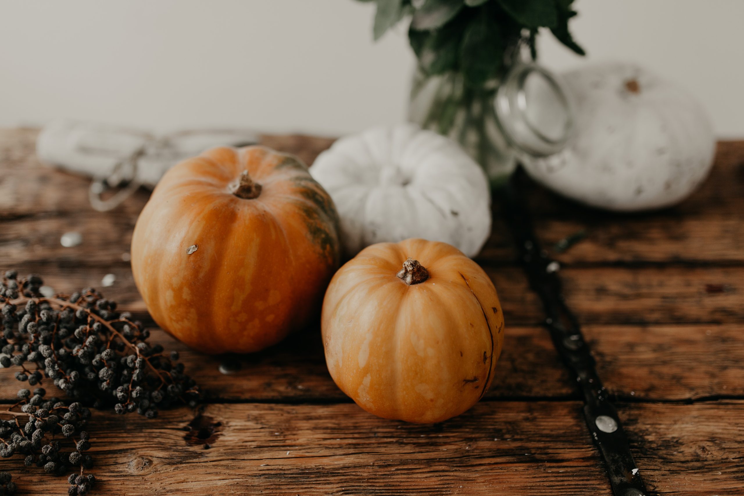 Autumn pumpkins and seasonal produce styled on a rustic wooden table
