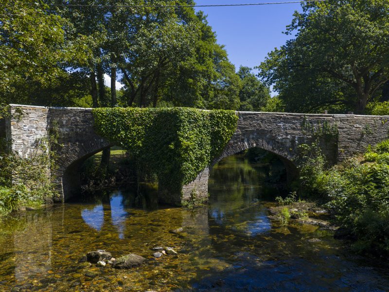 Helland Bridge, a historic stone bridge over a woodland stream Bodmin, North Cornwall